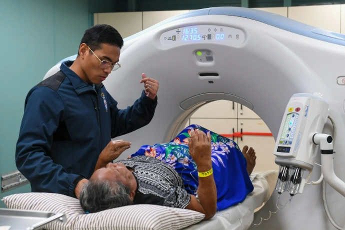 Medical professional assists patient during ct scan procedure.